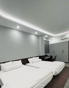 Habitación con 2 camas blancas y TV. en BITA HOTEL CẦN THƠ, en Bình Thủy