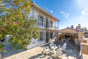 an exterior view of a house with a patio at Archodiko Palio Klima - Infinite Blue Elegance in Neo Klima
