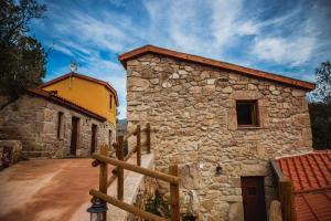 a stone building with a fence in front of it at Cascata do Varosa in Vila Pouca