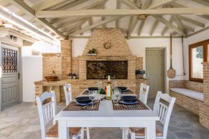 a dining room with a table and chairs and a fireplace at Archodiko Palio Klima - Infinite Blue Elegance in Neo Klima