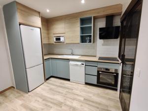 a small kitchen with a refrigerator and a sink at Duerme a gusto - Tu habitación acogedora en Torredonjimeno in Torredonjimeno