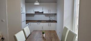 a kitchen with a wooden table and white cabinets at APARTAMENTOS IGLESIA DE SANTIAGo II in Jerez de la Frontera