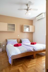 a bedroom with a bed with two red pillows on it at Apartman Adriatic Sea in Promajna