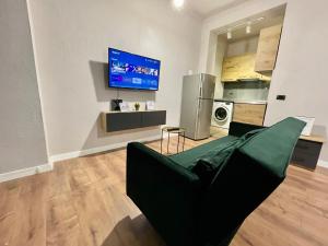 a living room with a couch and a tv on a wall at Keon superb studio apartament in Tirana