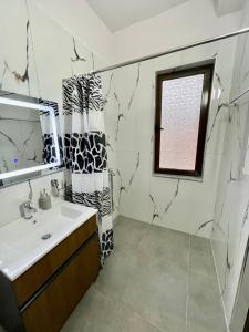 a bathroom with a sink and a mirror at Keon superb studio apartament in Tirana