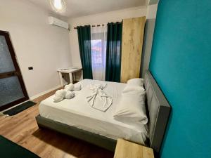 a bedroom with a bed with white sheets and towels at Keon superb studio apartament in Tirana