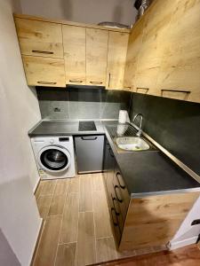 a small kitchen with a sink and a washing machine at Keon superb studio apartament in Tirana