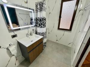 a bathroom with a sink and a mirror at Keon superb studio apartament in Tirana +24 photos
