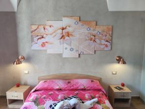 a bedroom with a bed with four paintings on the wall at Pantaleone Holiday House in Catania