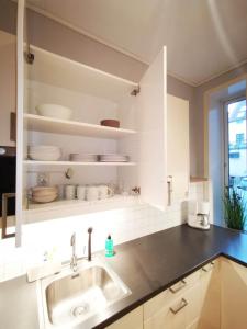 a kitchen with white cabinets and a sink and a window at Håkonsgaten in Bergen