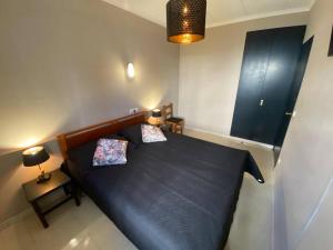 a bedroom with a large black bed with two pillows at Apartamento Europa con terraza in Blanes +19 photos