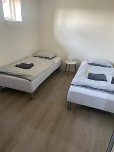 two beds in a bedroom with a wooden floor at Mejrup Bed and Breakfast in Holstebro