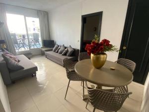 a living room with a table with a vase of flowers on it at Apartamento Europa con terraza in Blanes