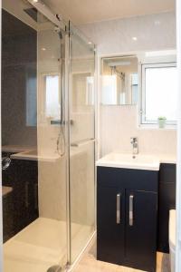 a bathroom with a glass shower and a sink at Sherwood Pines - Big Garden! in Clipstone