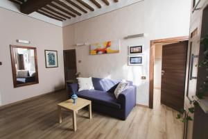 a living room with a blue couch and a table at Ad un passo dal Duomo in Orvieto