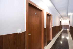 a corridor with wooden doors in a building at Yours Pacific in Jhājra