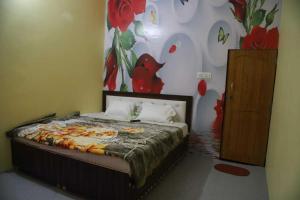 - une chambre avec un lit orné d'une fresque murale représentant des fleurs dans l'établissement OYO Hotel Grand AB, à Meerut