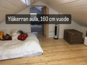 a bedroom with a white bed and a wooden floor at Villa Oiva in Ylihärmä