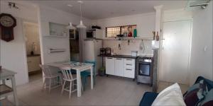 una cocina con electrodomésticos blancos, mesa y sillas en Studio Portal dos Corais apartamento 1003, en Recife