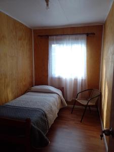a small bedroom with a bed and a window at Rita in Lota