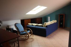 a living room with a blue couch and a table at Casaci in Acireale