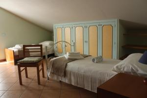 a bedroom with a bed and a chair and a table at Casaci in Acireale