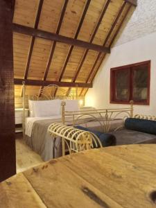 - une chambre avec un lit et un plafond en bois dans l'établissement Refúgio Pica-Pau - Monte Verde, à Monte Verde