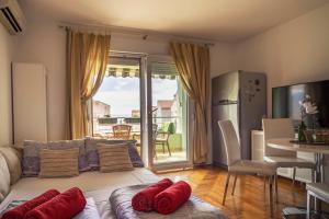a living room with a couch with red pillows on it at Apartman Adriatic Sea in Promajna