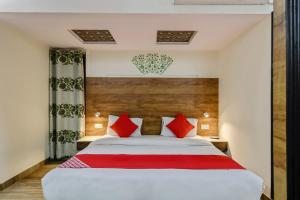 a bedroom with a large bed with red pillows at Collection O HOTEL TULIP PALACE in Jaipur
