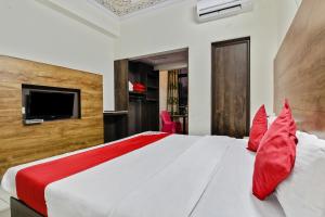 a bedroom with a large white bed with red pillows at Collection O HOTEL TULIP PALACE in Jaipur