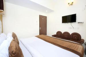 a bedroom with a bed with a television on the wall at OYO Hotel Sallow International in Amritsar