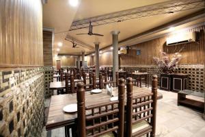 a restaurant with wooden walls and tables and chairs at OYO Hotel Sallow International in Amritsar