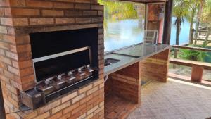 古利利的住宿－CASA AMARELA Beira Rio Guriri，庭院内带吧台的砖砌壁炉