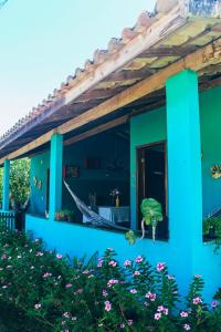 a blue house with a plant in the yard at Pousada Sítio da Floresta in Sana