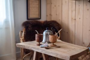 una mesa de madera con dos tazas y un hervidor de agua. en Studio Insolite Viking, en Caen