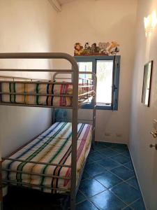 2 stapelbedden in een kleine kamer met een raam bij Casa dei Fiori in Donnalucata