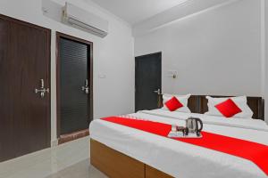 坎普爾的住宿－Flagship Sai Galaxy Hotel & Restaurant，一间卧室配有一张带红色和白色枕头的大床