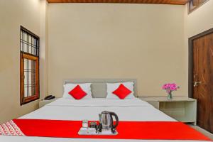 坎普爾的住宿－Flagship Sai Galaxy Hotel & Restaurant，卧室配有带红色枕头的白色床