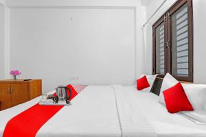 坎普爾的住宿－Flagship Sai Galaxy Hotel & Restaurant，卧室配有红色色调的白色床