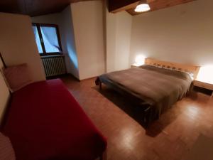Un dormitorio con una cama y un banco rojo. en Ciasa Oriella, en Cibiana