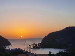 einen Sonnenuntergang über einem Wasserkörper mit der Sonne in der Unterkunft Casa Vista in Marigot-Bucht