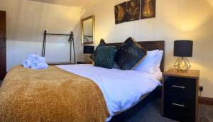 a bedroom with a large bed with blue towels on it at Forget Me Not Cottage in Ironbridge +8 photos