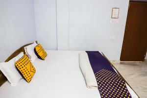 a bed with yellow and blue polka dotted ties on it at SPOT ON Nanki Palace in Ajmer