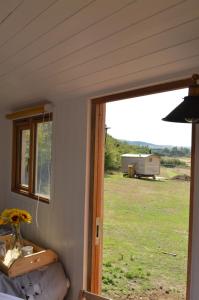 okno w pokoju z widokiem na pole w obiekcie Under the Stars Shepherds Huts at Harbors Lake w mieście Newchurch