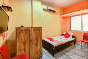 een kleine kamer met een bed en een televisie bij Super OYO Hotel Priyal Amrit Sagar in Rourkela