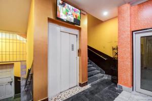 una puerta blanca en una habitación con escaleras y TV en Super OYO Hotel Priyal Amrit Sagar, en Rourkela