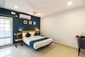 een slaapkamer met een bed en een blauwe muur bij Silverkey Himayat Nagar Circle Near Snow World in Hyderabad