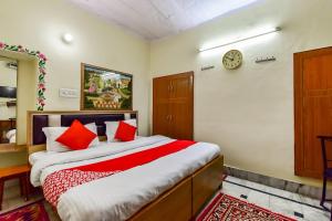 a bedroom with a bed and a clock on the wall at Super OYO Dev Villas Guest House in Jodhpur
