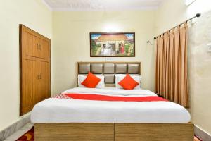 a bedroom with a large bed with orange pillows at Super OYO Dev Villas Guest House in Jodhpur