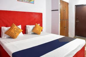 a bedroom with a bed with orange and blue pillows at SPOT ON Hotel Krrish in Durg